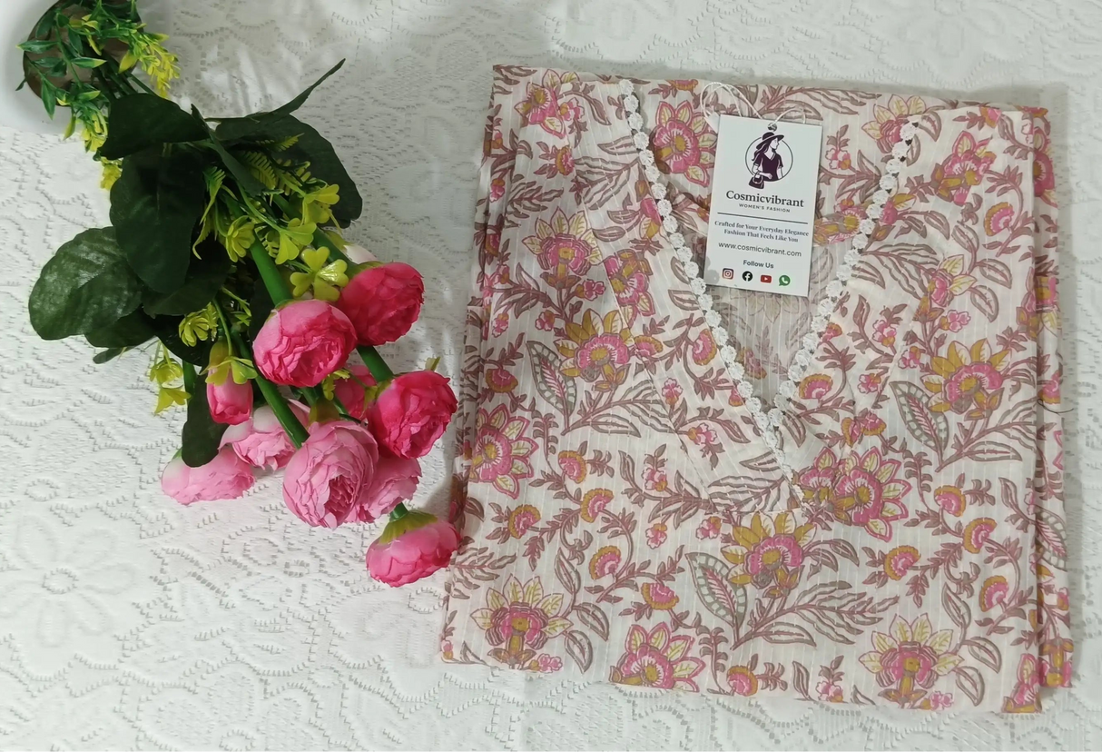 Floral-patterned shirt on a white surface with pink flowers and green leaves.