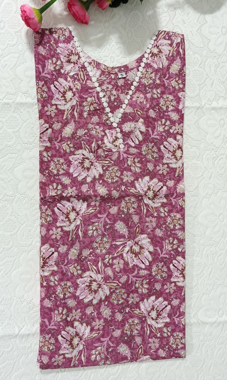 Floral-patterned fabric on a white surface with pink flowers and green leaves.