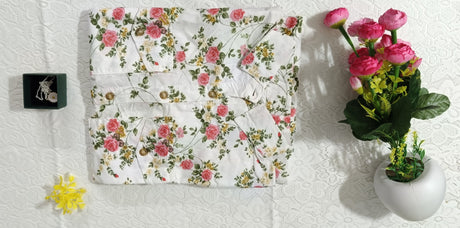 Floral-patterned fabric on a white surface with a small vase of flowers.