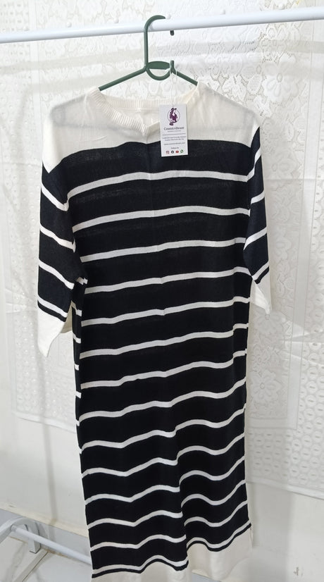 Black and white striped dress on a hanger with a white background