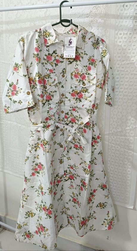 Floral dress hanging on a rack against a textured white wall