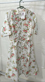Floral dress hanging on a rack against a textured white wall