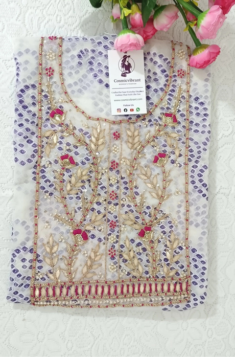 Decorative tablecloth with floral pattern and tag on a white surface with pink flowers.