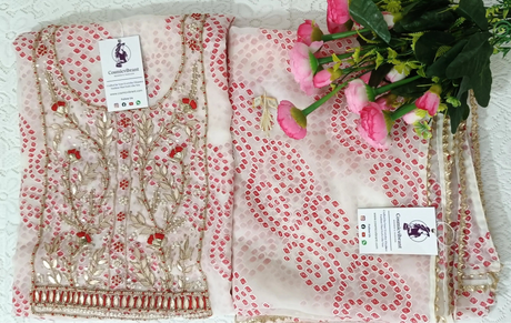 Decorative fabric with floral patterns on a white surface with flowers in the foreground.