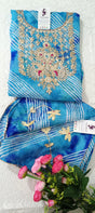 Blue embroidered fabric with gold detailing on a white background